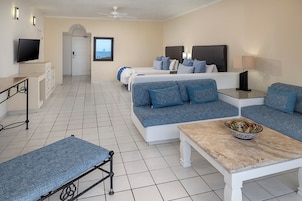 Una habitación de hotel con cama, sofá, mesa y televisor.