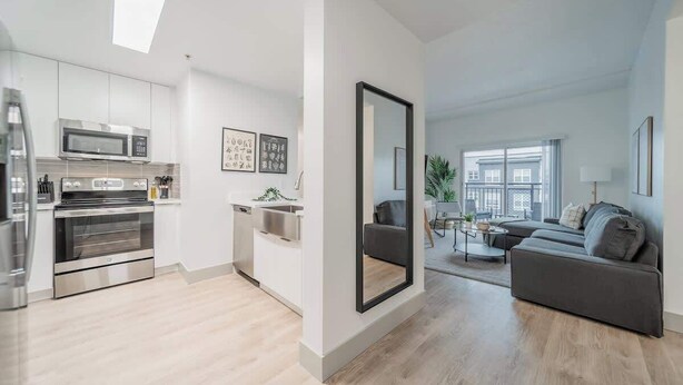 A modern apartment with a kitchen, living area, and a large mirror. - 4BR with Balcony and City View + Parking (Charlotte)