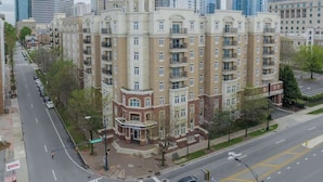 A multi-story hotel with a central courtyard, surrounded by a cityscape. - Uptown 4 Bed w Balcony Downtown, Parking (Charlotte)