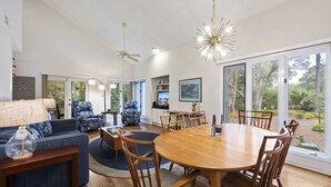 A spacious living area with a large wooden dining table, comfortable seating, and a ceiling fan. - Minutes to Beach & Golf | Pet-Friendly Villa (Hilton Head Island)