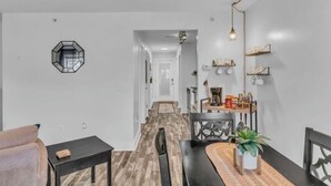 Eine moderne Küche mit Holzboden, einem Esstisch und einer Hängelampe.