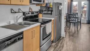 Eine moderne Küche mit Holzausbau, Edelstahlgeräten und einem Essbereich mit Tisch und Stühlen.