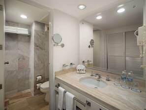 Une salle de bain moderne avec une douche en marbre, un grand lavabo avec un miroir et des toilettes.