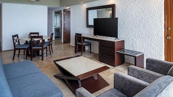 Ein modernes Wohnzimmer mit einer Couch, einem Couchtisch und einem an einer strukturierten Wand montierten Fernseher.