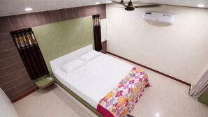 A hotel room with a bed, a ceiling fan, an air conditioning unit, and a tiled floor. - Park Inn (Port Blair)