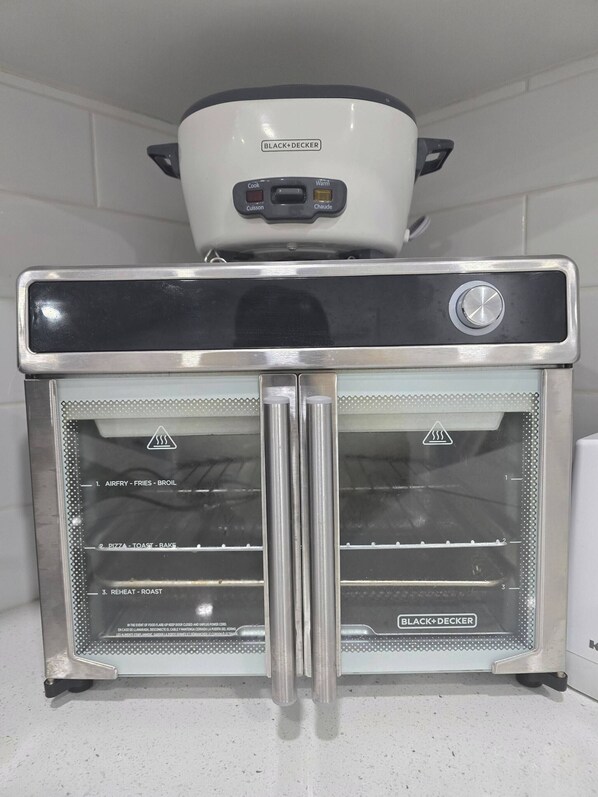 A BLACK+DECKER air fryer with a control panel and two glass doors. - Cy Becker Drive 2023 Luxury Home (Edmonton)