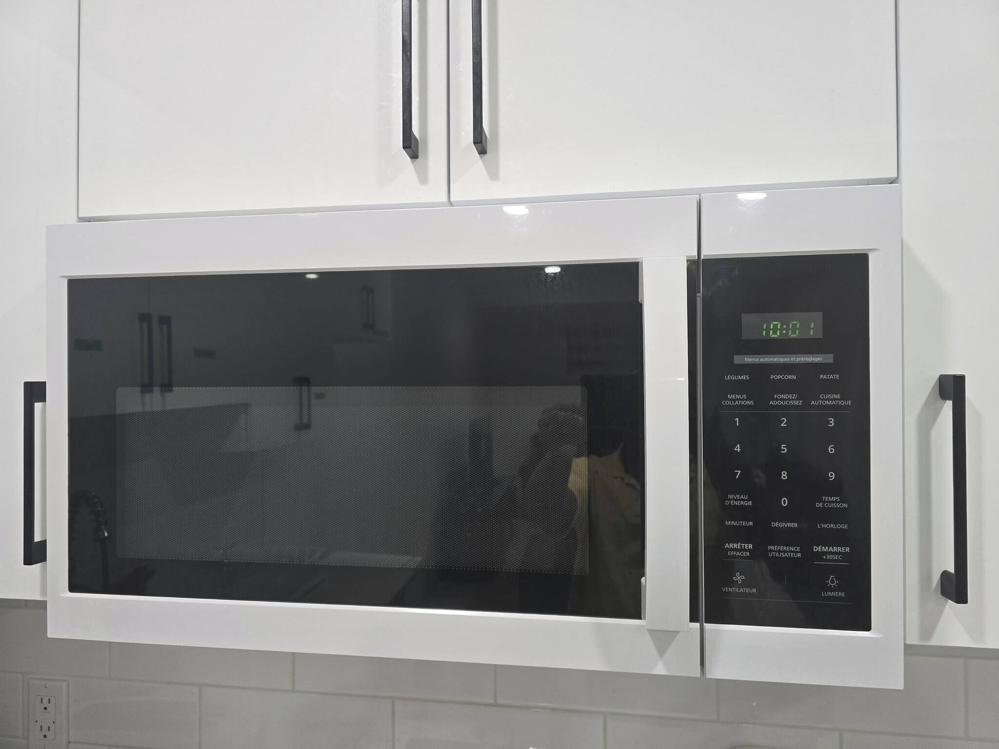 A white microwave oven with a digital display and a control panel.
