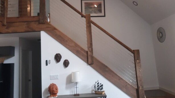 A wooden staircase with a white wall and a framed picture above it.