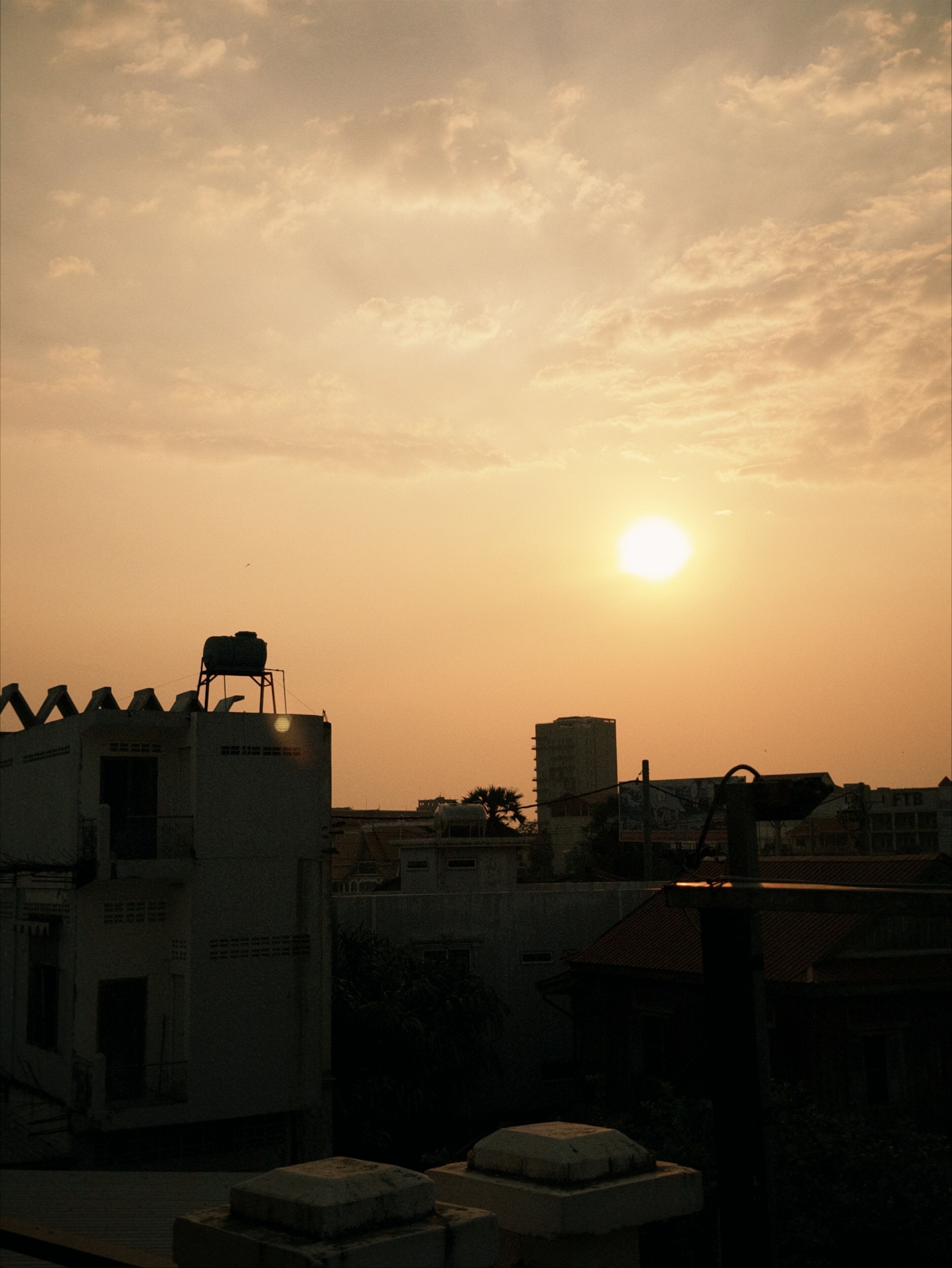 Un atardecer sobre un paisaje urbano con edificios recortados contra el cielo.