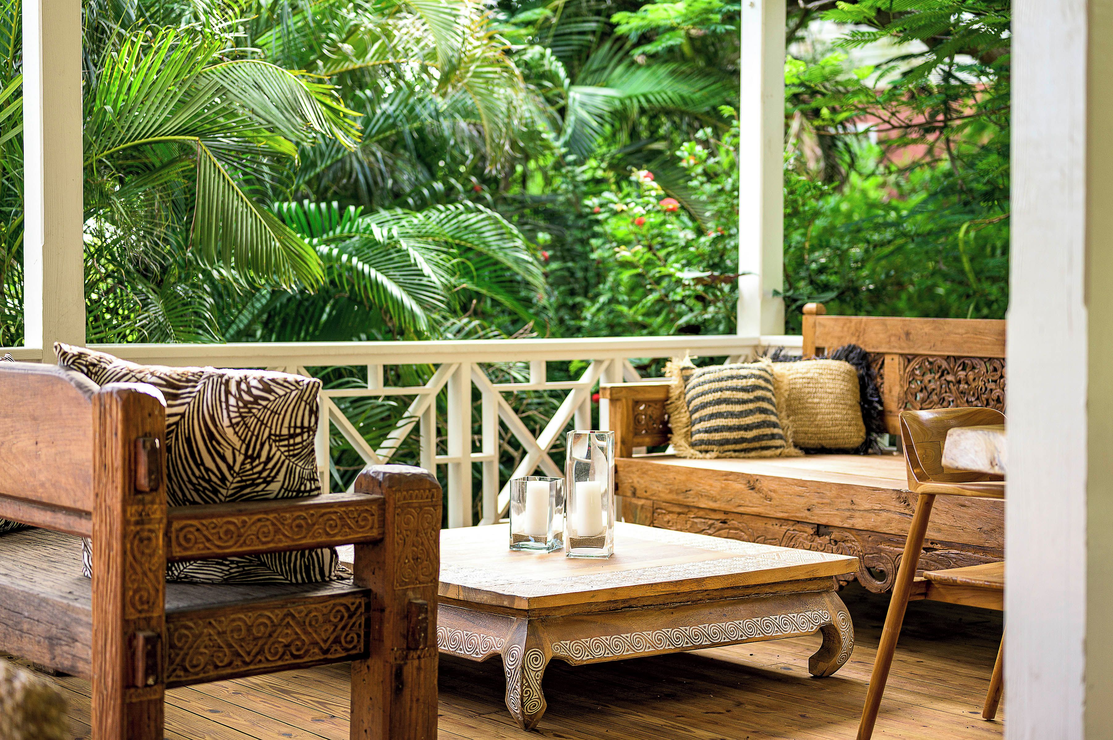 A wooden outdoor seating area with a view of lush greenery.