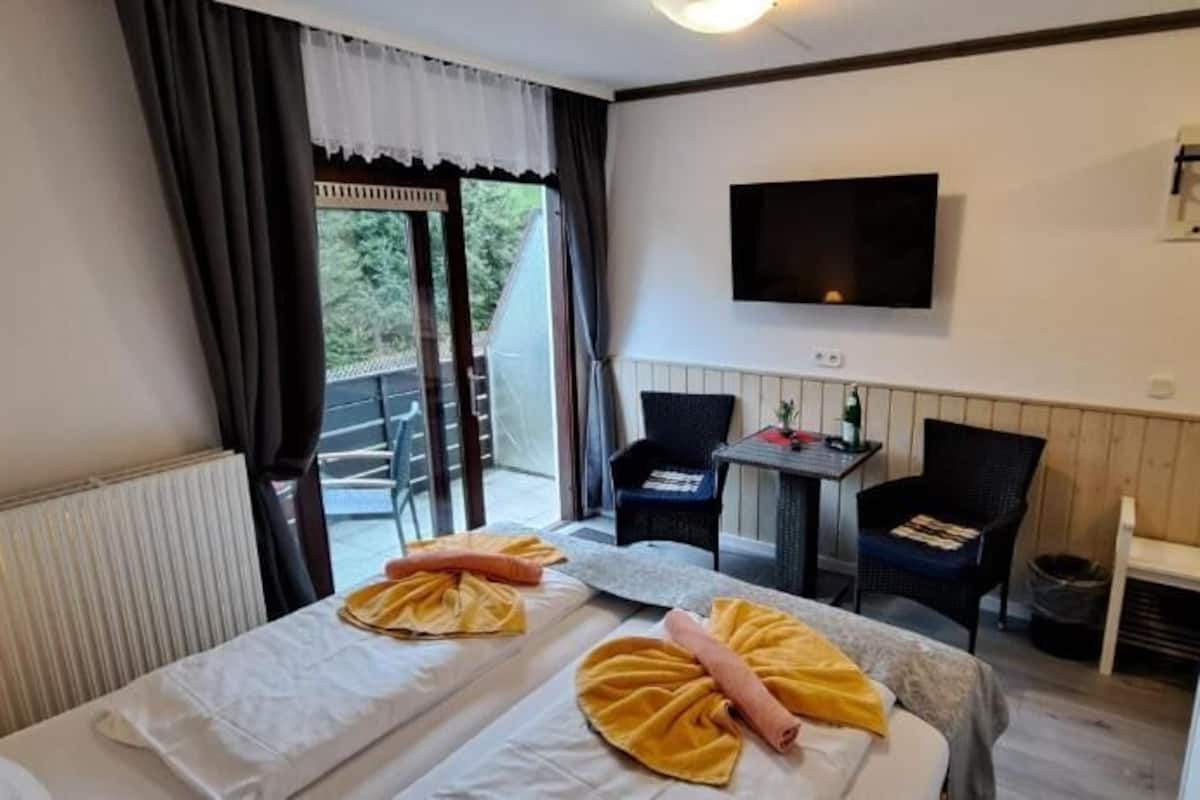 Une chambre d’hôtel avec deux lits, une télévision, une petite table et une chaise.
