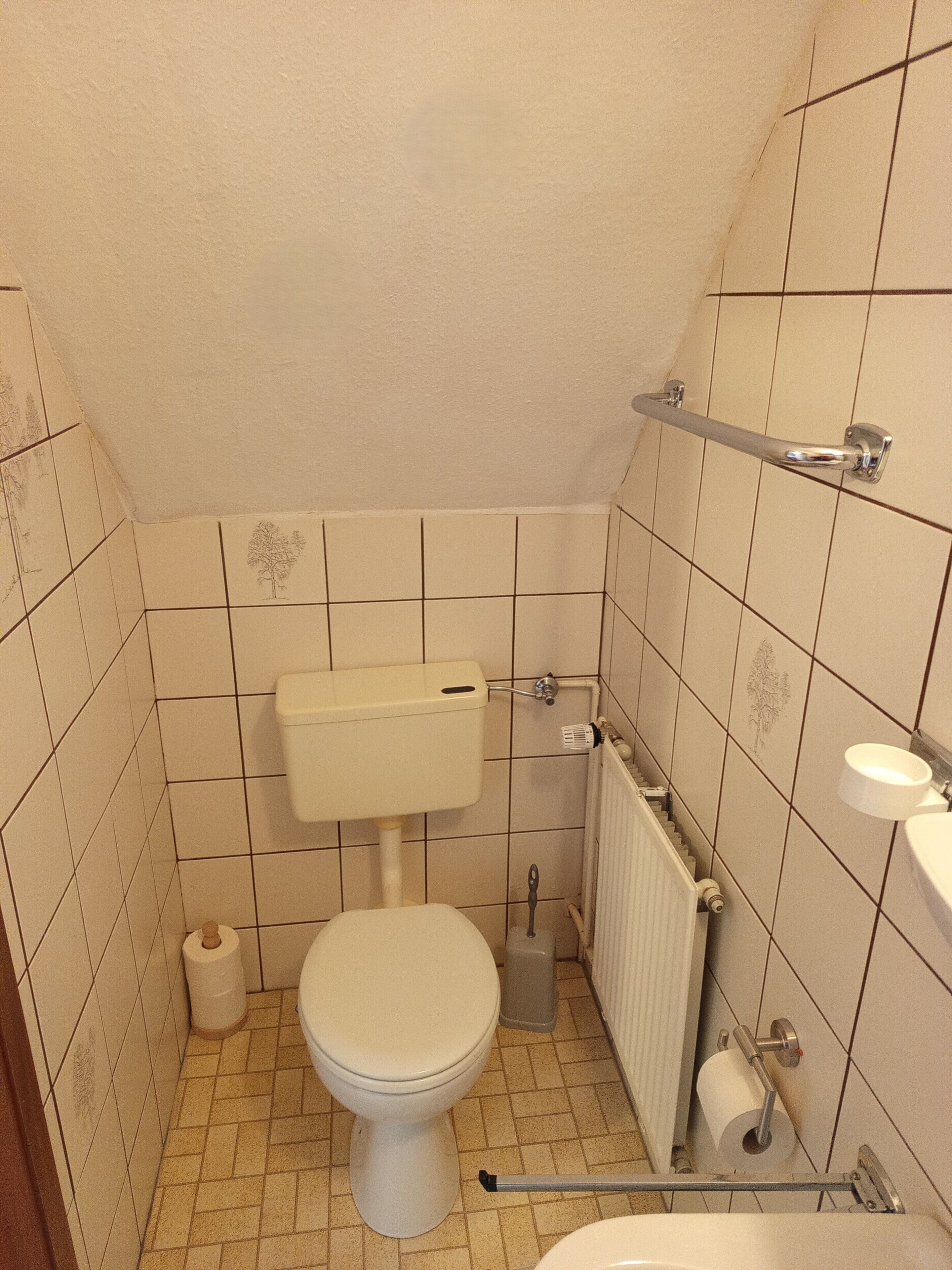 Un baño pequeño con azulejos, un inodoro, un bidé y un radiador.