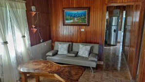 Ein Zimmer mit Holzwänden, einer Couch, einem Couchtisch und einem Bild an der Wand.