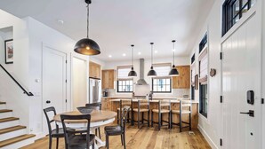 Una cocina moderna con armarios de madera, una isla central e iluminación colgante.