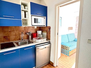 A compact kitchen with blue cabinets, a microwave, a coffee maker, and a dishwasher. - Studio for 4 with Wi-Fi, sea view from terrace (Roquebrune-Cap-Martin)