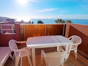 A terrace with a white table and four white chairs, overlooking a coastal view. - Studio for 4 with Wi-Fi, sea view from terrace (Roquebrune-Cap-Martin)
