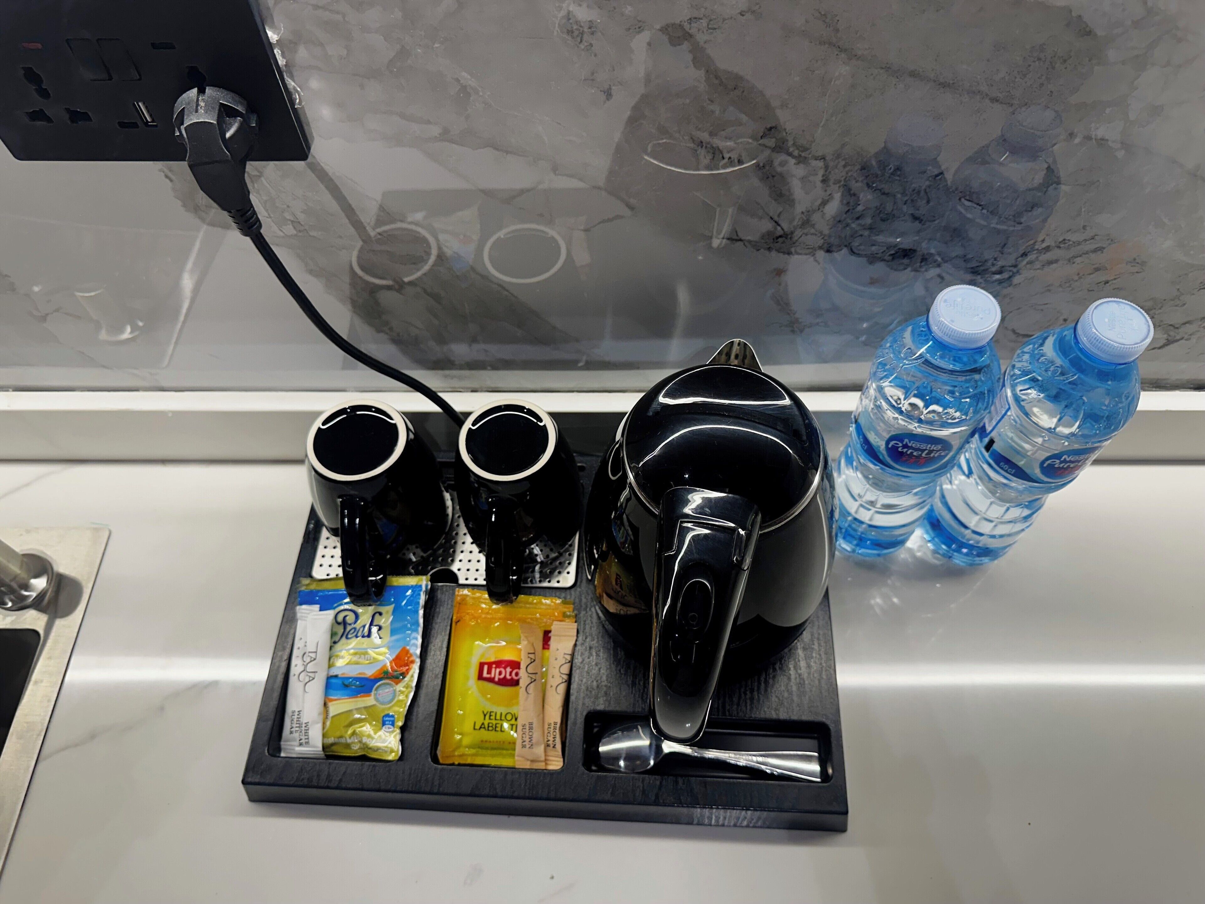 Eine Kaffeestation mit Wasserkocher, zwei Tassen sowie Lipton-Tee und Kaffeeverdünner.
