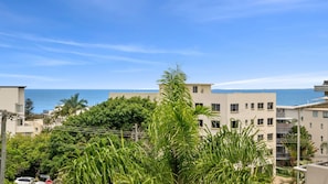 Eine Wohngegend an der Küste mit Gebäuden, blauem Himmel und Blick auf das Meer.