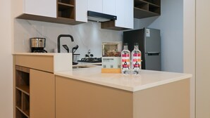 A kitchen with a white countertop, a coffee maker, a refrigerator, and a sign for 'DESCUBRE PERU.' - w* | Amazing 1BR Apartment in Heart of San Isidro (San Isidro)