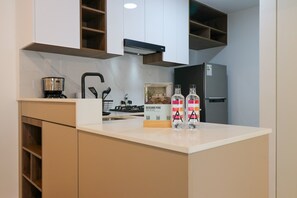 Eine Küche mit weißer Arbeitsplatte, einer Kaffeemaschine, einem Kühlschrank und einem Schild mit der Aufschrift 'DESCUBRE PERU'.