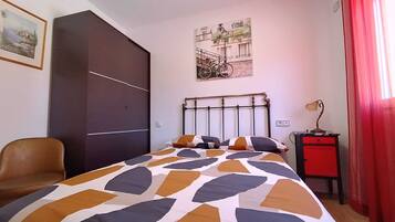 Tabla de planchar con plancha y ropa de cama