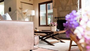 A cozy living room with a stone fireplace, a wooden coffee table, and a comfortable sofa. - Killay B1 - Gorgeous 3-bedroom villa in Calca perfect for your getaway (Calca)