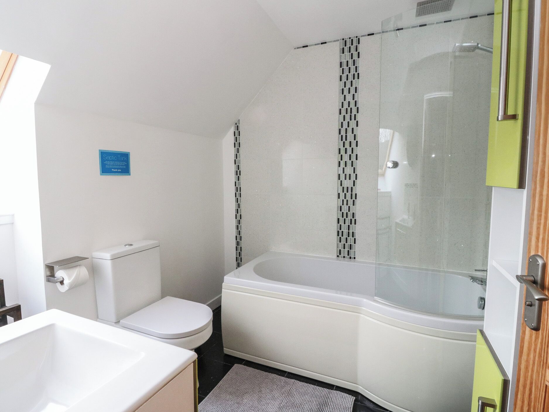 A bathroom with a toilet, a sink, and a glass-enclosed shower.