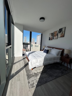 A modern bedroom with a large bed, a view of city buildings, and a skylight. - Miami-Brickell Skyline Lux High Rise 2BR-2B -walking distance to KASEYA-BAYSIDE (Miami)