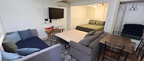 A compact living space with a sofa, a dining table, and a ceiling fan.
