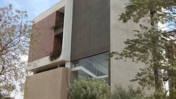 Un hôtel moderne, reconnaissable à son enseigne où l’on peut lire « Hôtel Karnawat Avenue ».