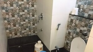 Une petite salle de bain avec des toilettes, un lavabo et une douche.
