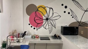 Een kleine keuken met een spoelbak, aanrecht en magnetron.