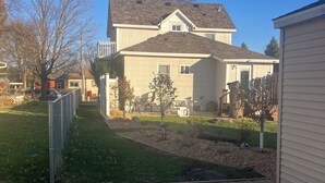 A residential house with a front yard, a gravel driveway, and a small garden area. - 2-bedroom apartment in charming Austin. (Austin)