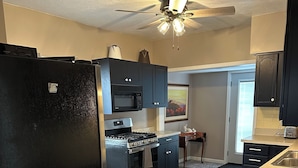 A modern kitchen with a black refrigerator, stainless steel appliances, and a ceiling fan. - 2-bedroom apartment in charming Austin. (Austin)