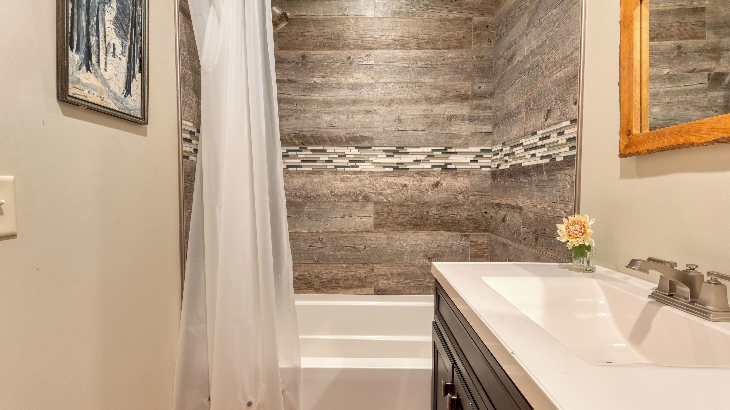 A modern bathroom with a shower, a sink, and a mirror.