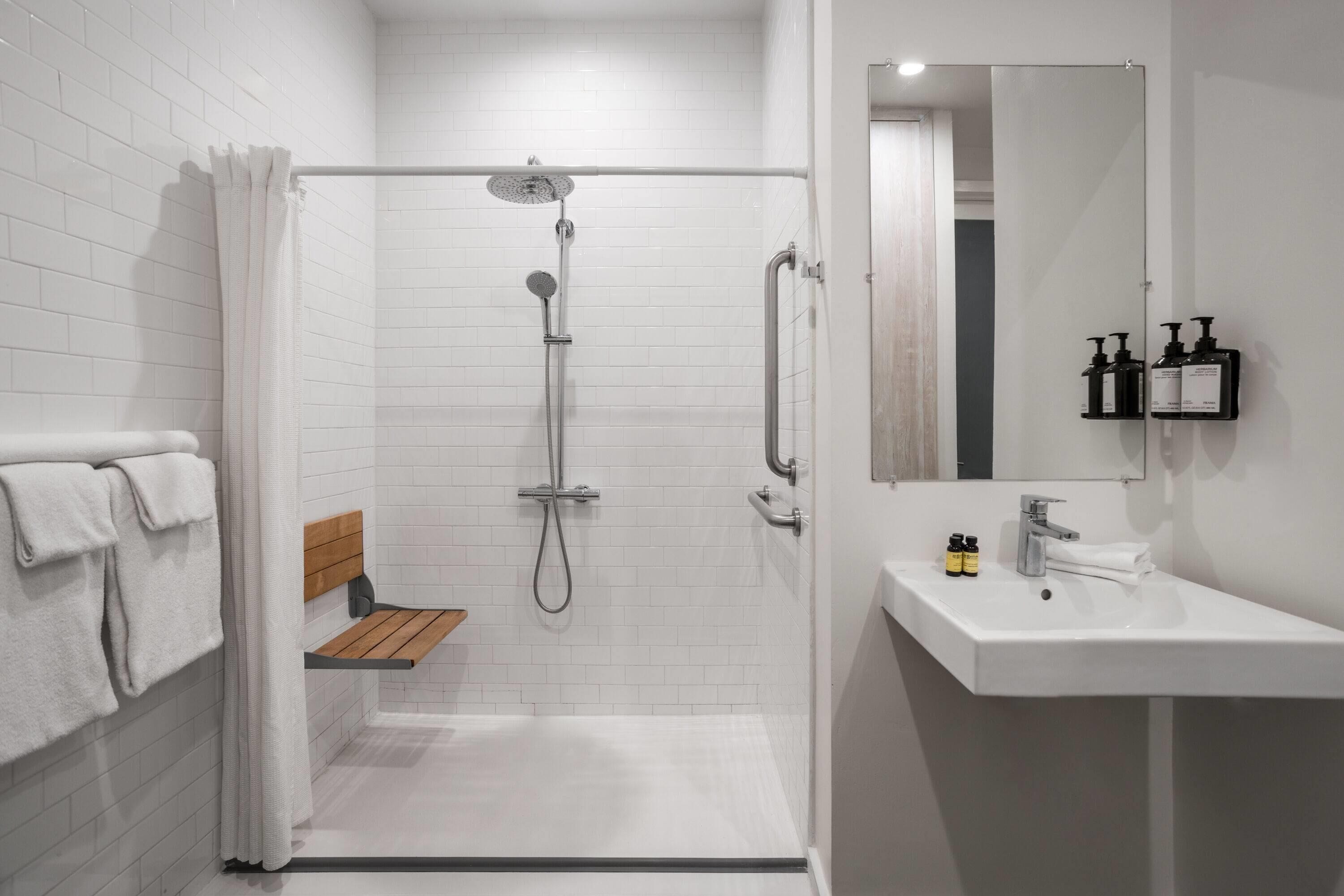 Une salle de bain moderne avec une douche, un lavabo et un miroir.