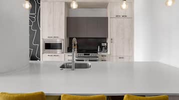 A modern kitchen with a central island, stainless steel appliances, and pendant lighting.