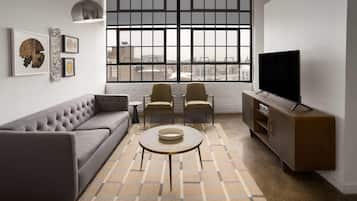 A modern living room with a sofa, two chairs, a coffee table, a TV, and artwork on the wall.
