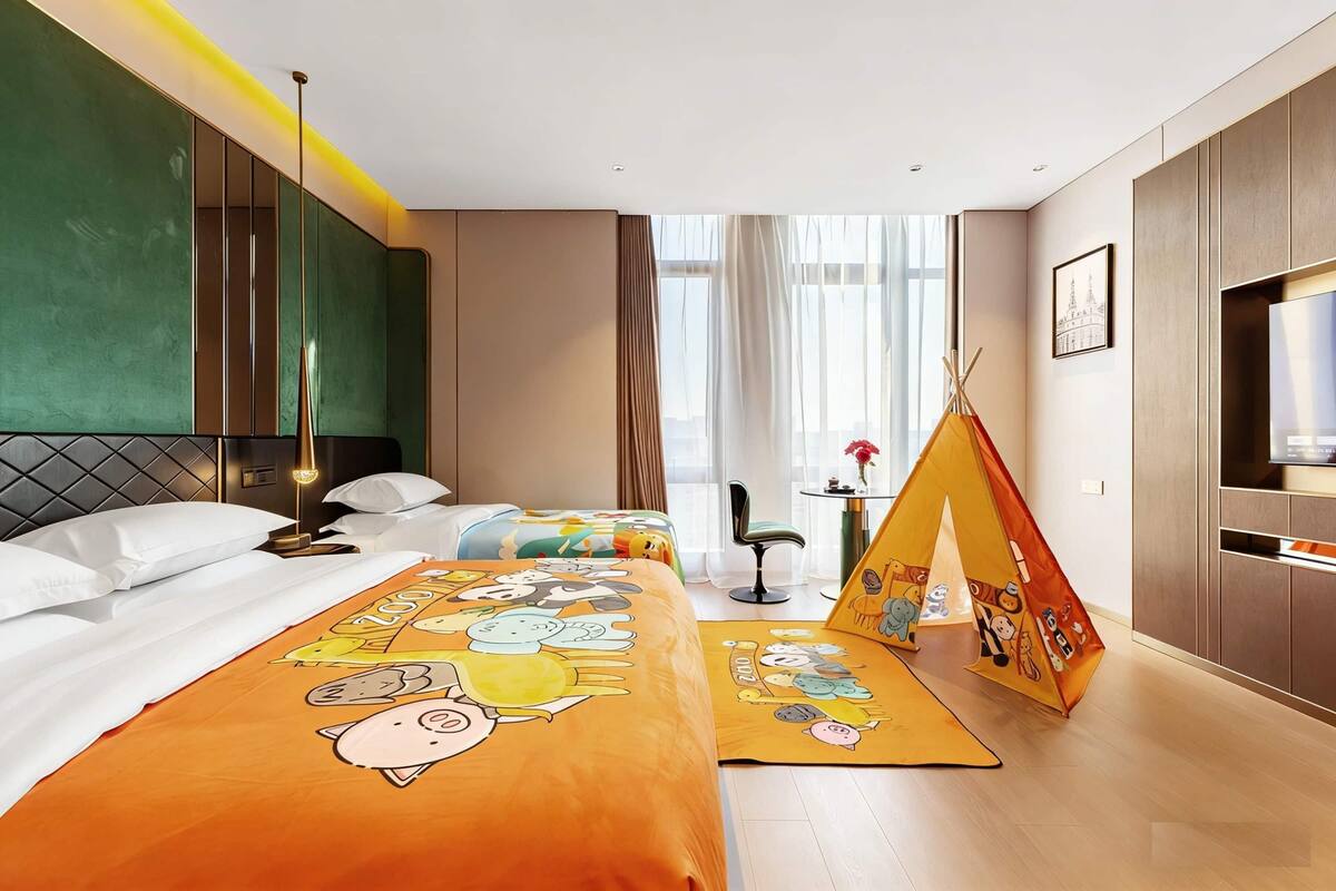 Una habitación de hotel con una cama, un sofá, un televisor, una ventana con cortinas y una tienda de campaña.