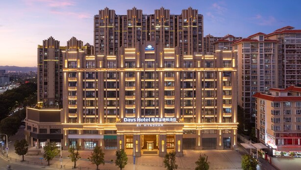 Un hôtel à plusieurs étages, doté d’une façade moderne, d’une enseigne lumineuse et d’une entrée bien visible.