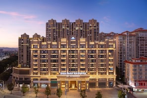 A multi-story hotel with a modern facade, illuminated signage, and a prominent entrance. - Days Hotel By Wyndham Shantou Longhu (Shantou)