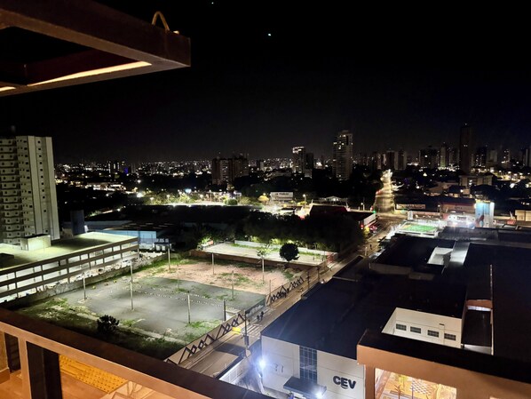 A nighttime cityscape with illuminated buildings and a sports field. - Studio Connect Life 804 (Teresina)