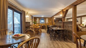 A cozy restaurant with wooden interiors, large windows, and a central archway. - Sleeps 40 Heated Pool Hot Tub Fire Pit Game Room Brookside Mountain Retreat by Avantstay (Stephentown)