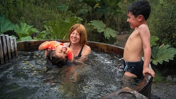 A hot tub with a wooden edge and a wooden bench.