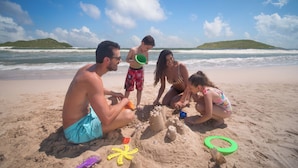 A beach scene with people playing in the sand, a starfish, and a green ring. - El Cid Castilla Beach Hotel - All Inclusive (Mazatlán)