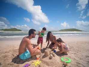 A beach scene with people playing in the sand, a starfish, and a green ring. - El Cid Castilla Beach Hotel - All Inclusive (Mazatlán)