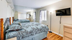 Ein Schlafzimmer mit zwei Betten, einem Fernseher, einem Schminktisch und einer Treppe.