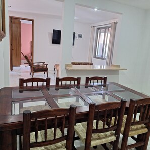 A dining area with a glass-top table and wooden chairs. - Depas Ocampo de Grupo Casa Mariano (Morelia)