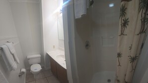 Een badkamer met toilet, wastafel en douche.