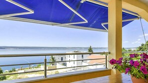 En balkon med udsigt over vand og bygninger i det fjerne.